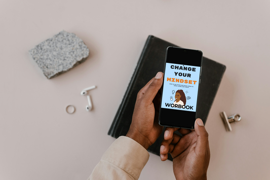 Person holding a phone with an ebook title Change your mindset