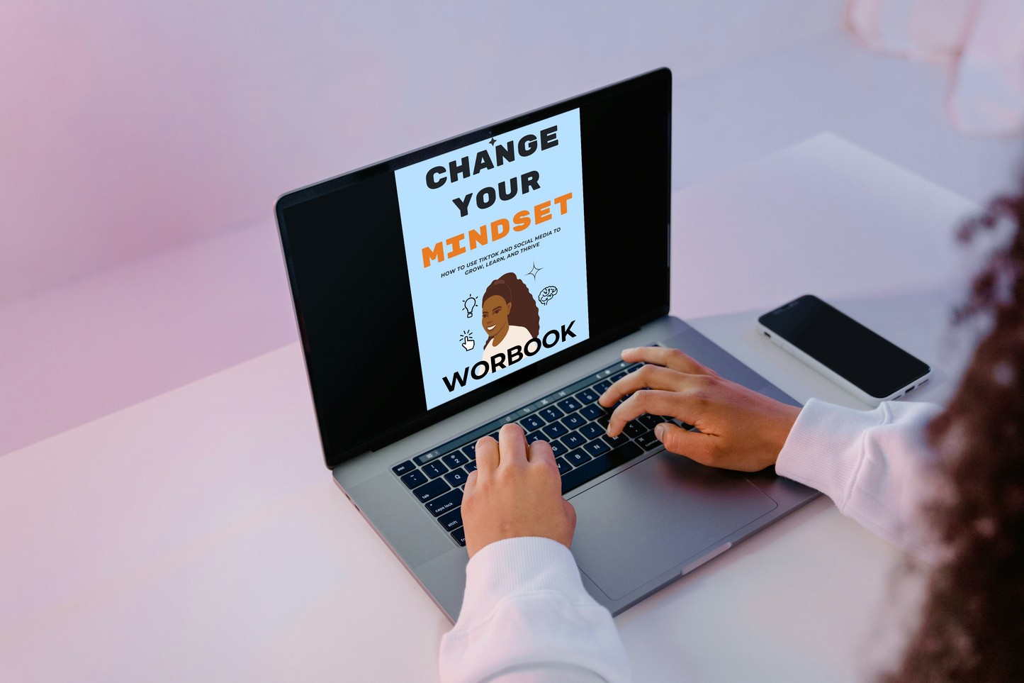 Person using a laptop with a 'Change Your Mindset Workbook' on the screen.